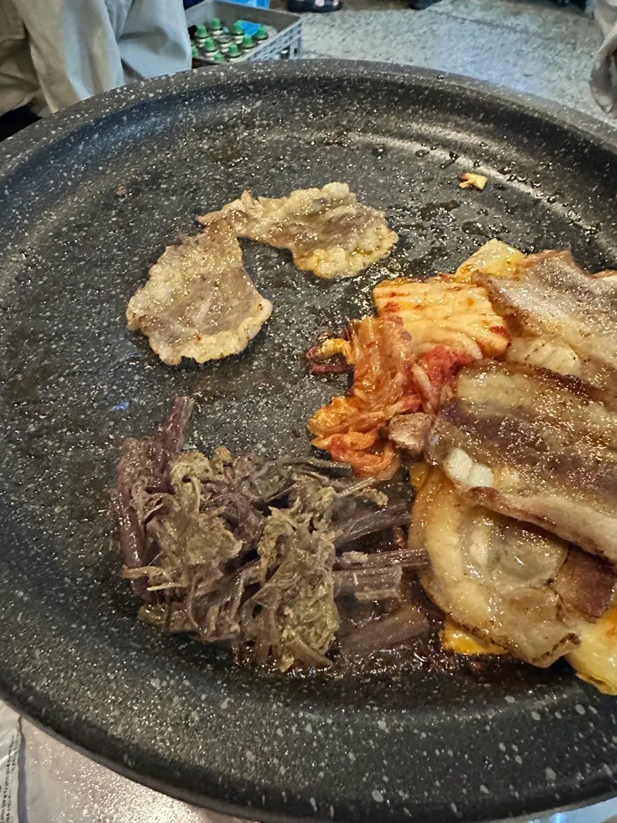 Pork belly, kimchi, and gosari together on the grill