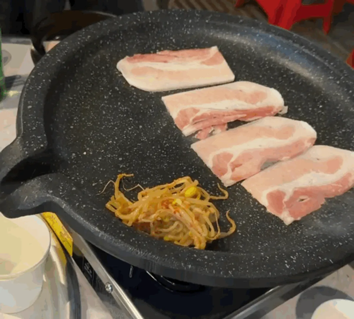 불판 위에서 익어가는 얇은 급냉 삼겹살