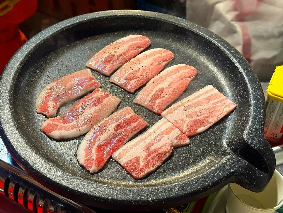 Beef short rib belly and frozen pork belly laid on the grill