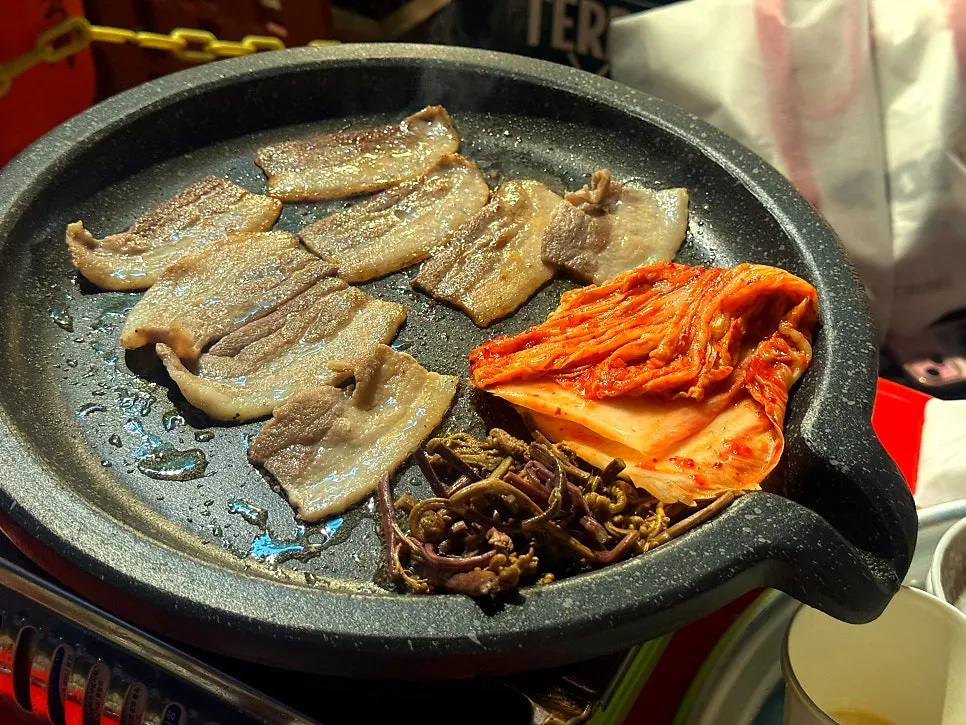 The tent-side grill sizzling with meat