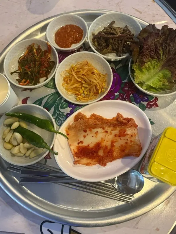 Naengsam and grilled side dishes cooking on the griddle