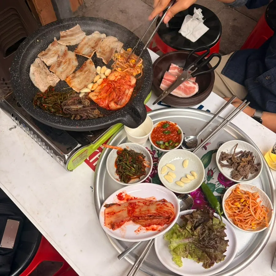 고기와 반찬이 차려진 야장 테이블 한 상