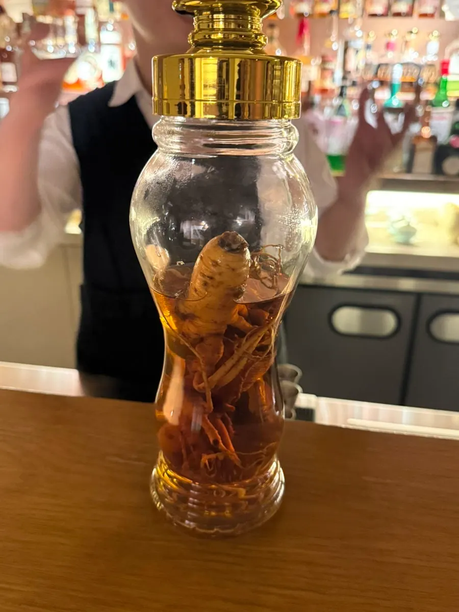 A liquor bottle containing a whole ginseng root