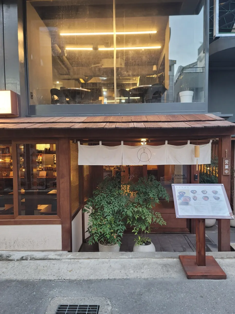 瓦屋根の軒先と白い暖簾がある日本料理店の外観