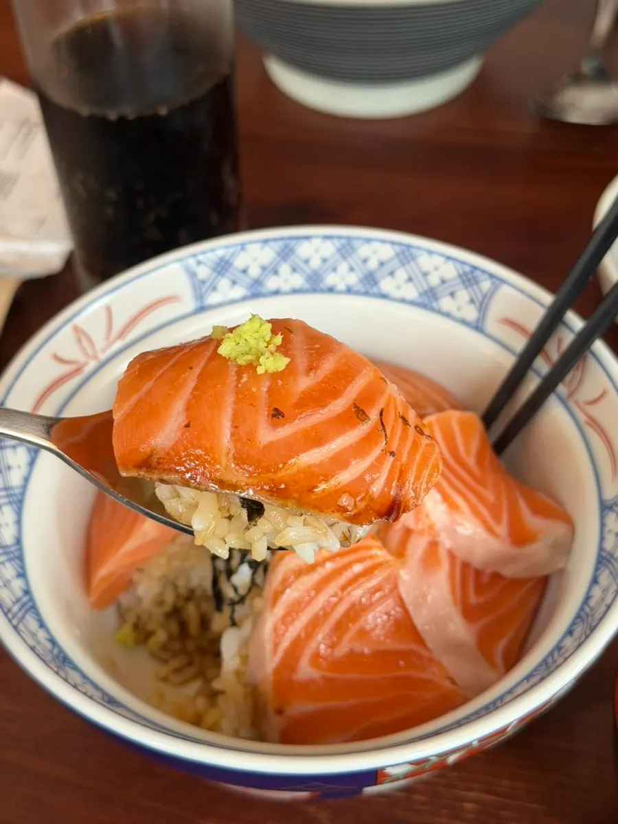 Dipping the salmon into the side soy sauce