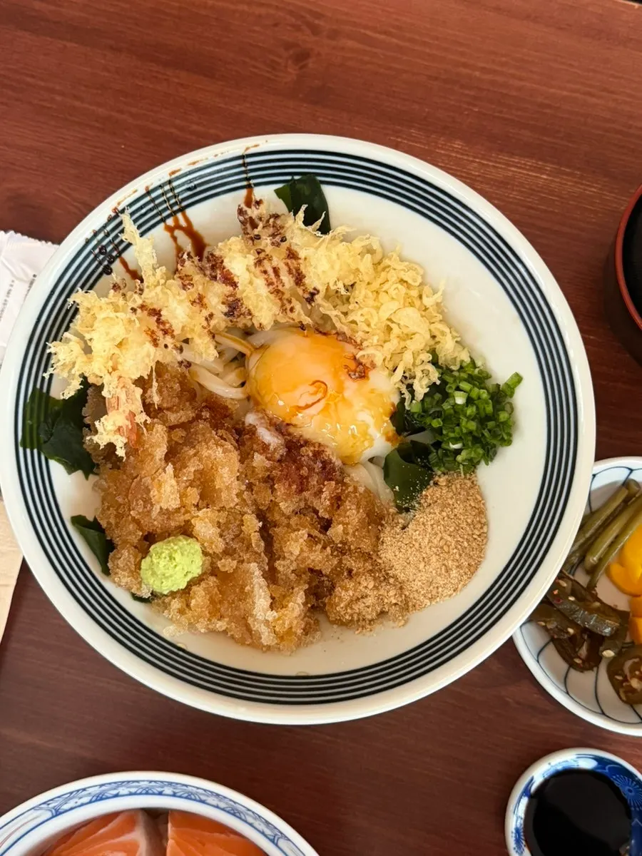 Bukkake cold udon topped with icy broth, poached egg, and fried shrimp