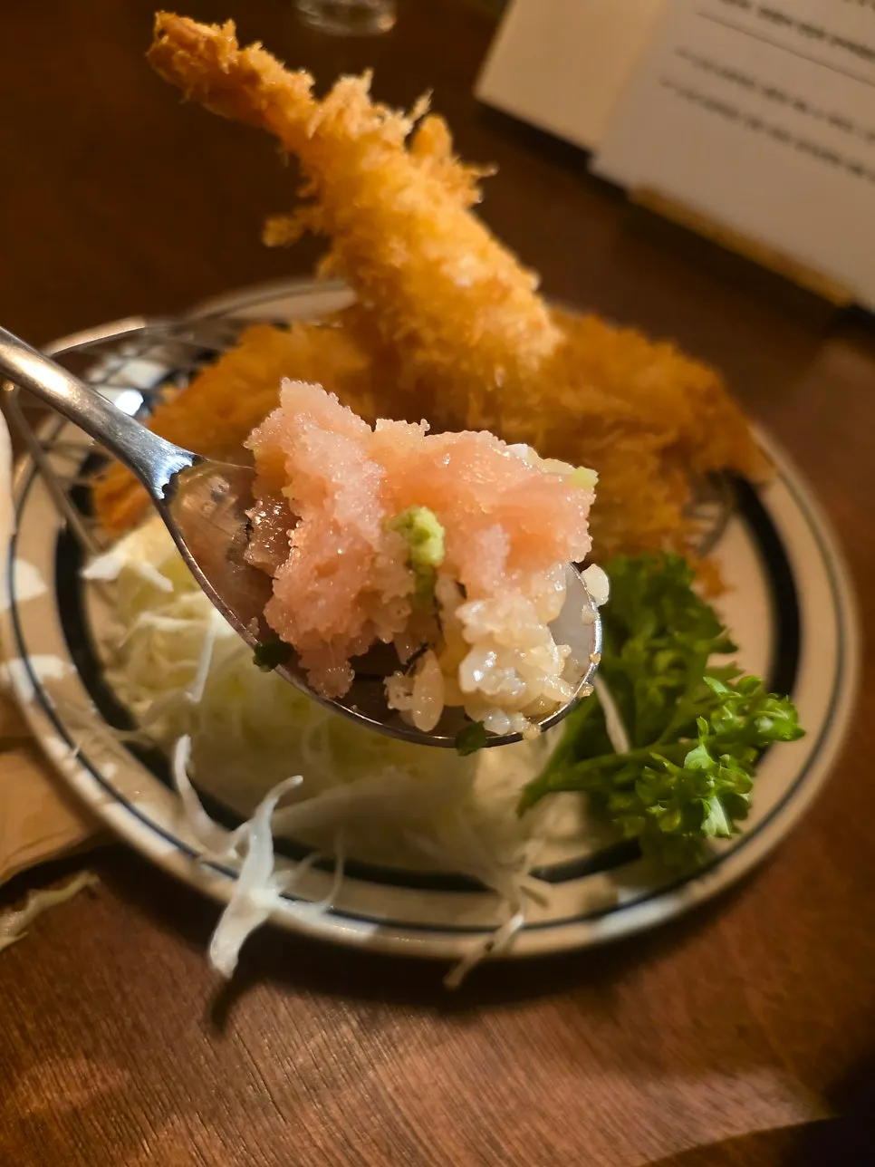 A spoonful of rice topped with salmon and white pollock roe