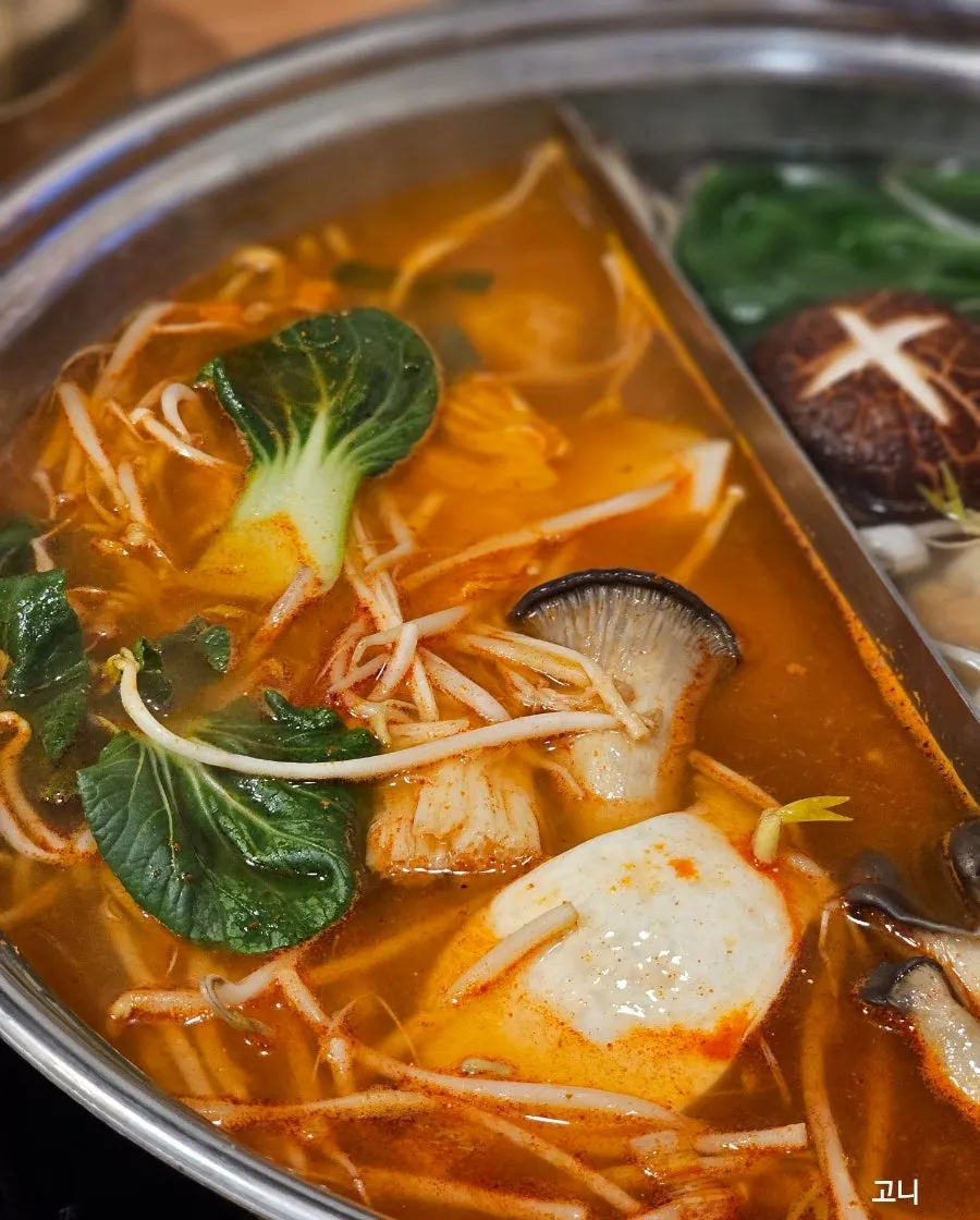 반반육수 만두전골과 반찬이 놓인 테이블