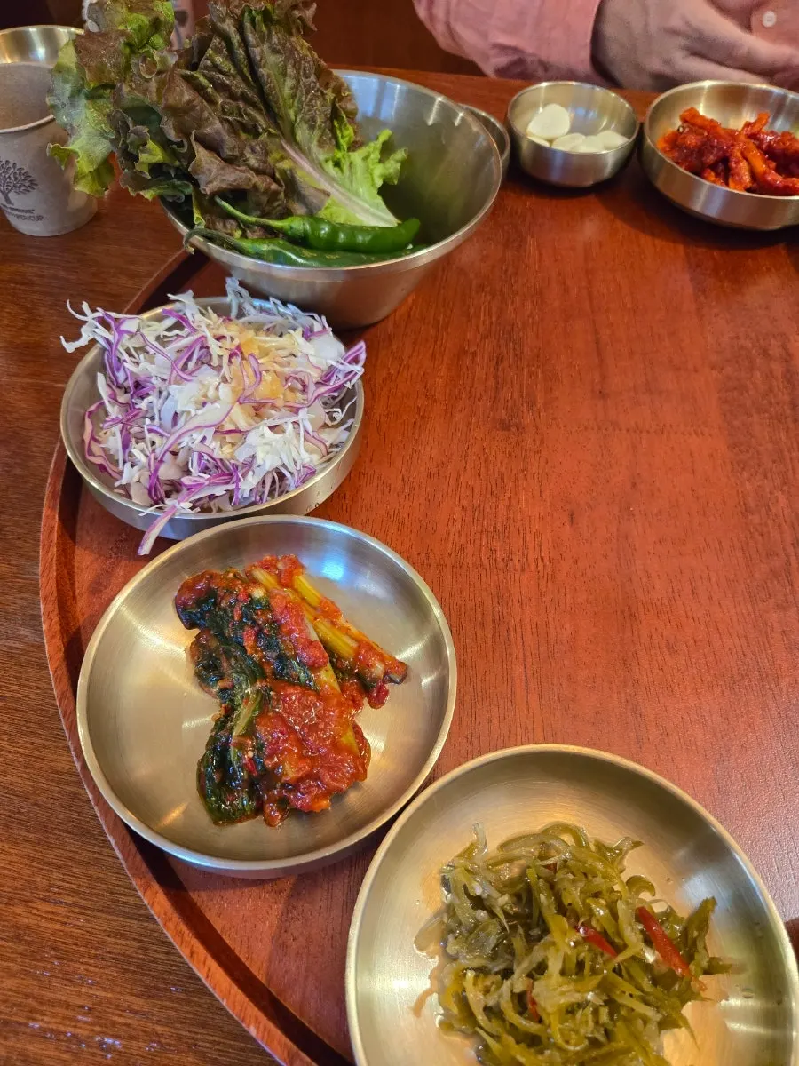 Wild garlic leaves and baek kimchi arranged on a round tray