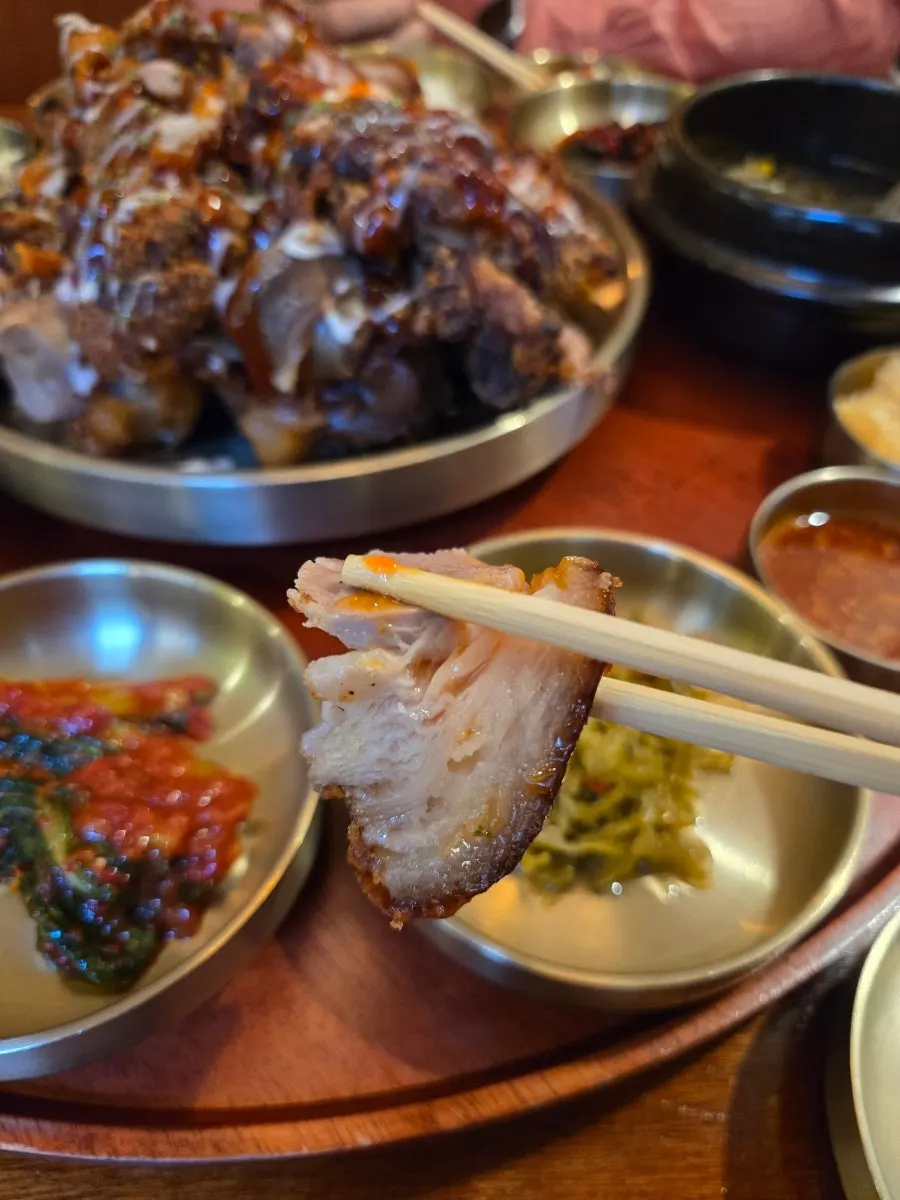 A piece of fried jokbal picked up with chopsticks