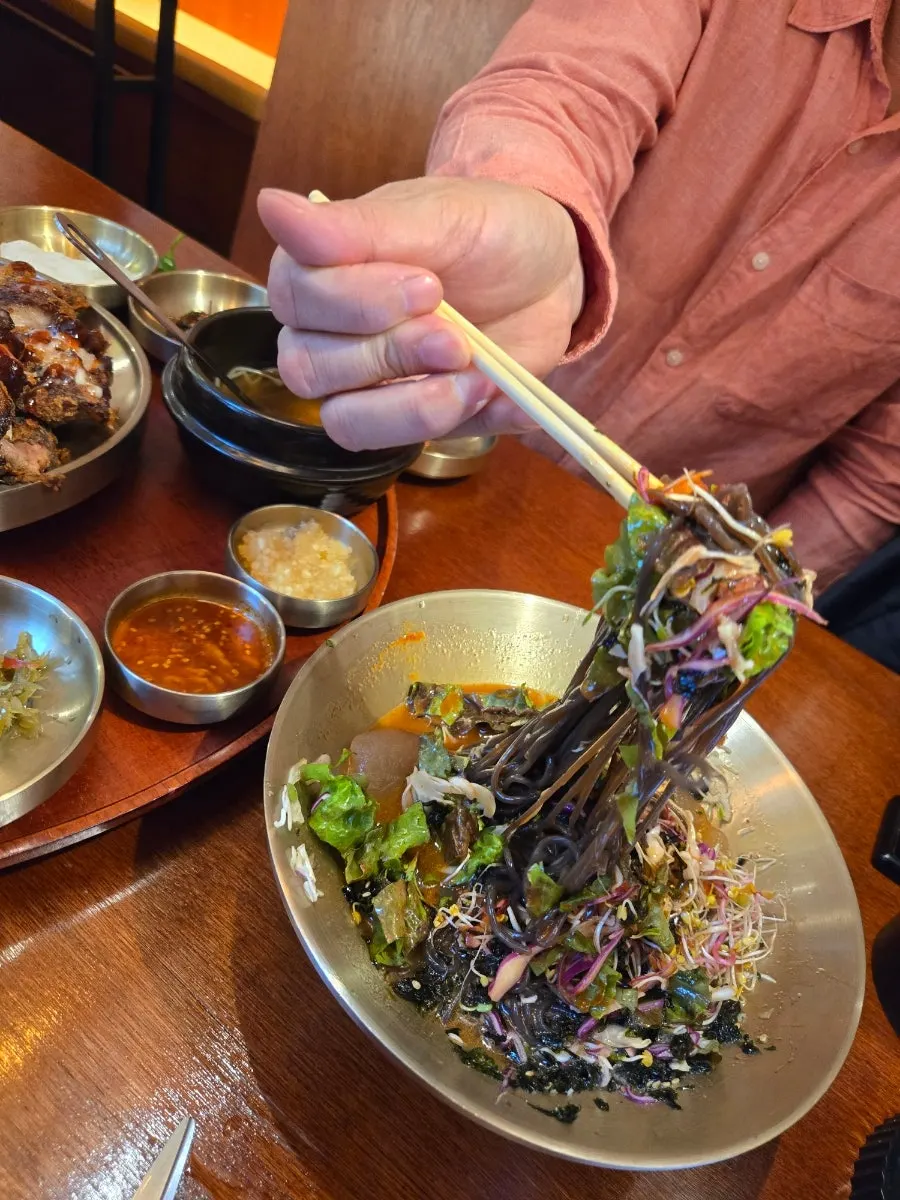 A piece of jokbal placed on top of buckwheat noodles