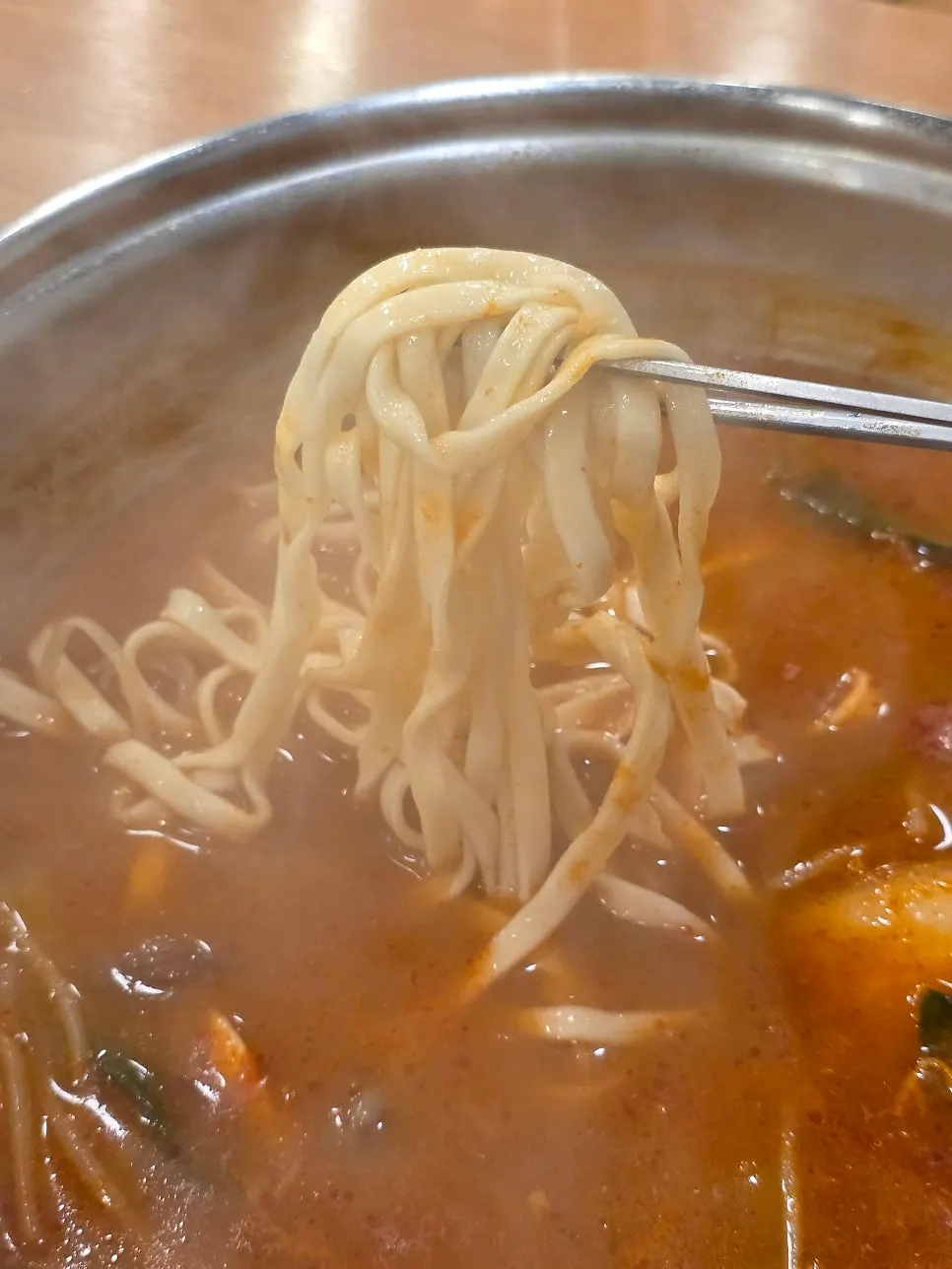 Kalguksu noodles lifted out of the broth