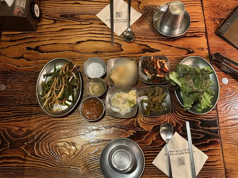 Side dish spread including lettuce, green onion, and white kimchi