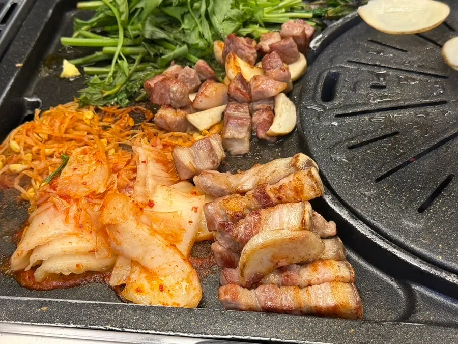 Water dropwort, kimchi, and bean sprouts grilling together on the pan