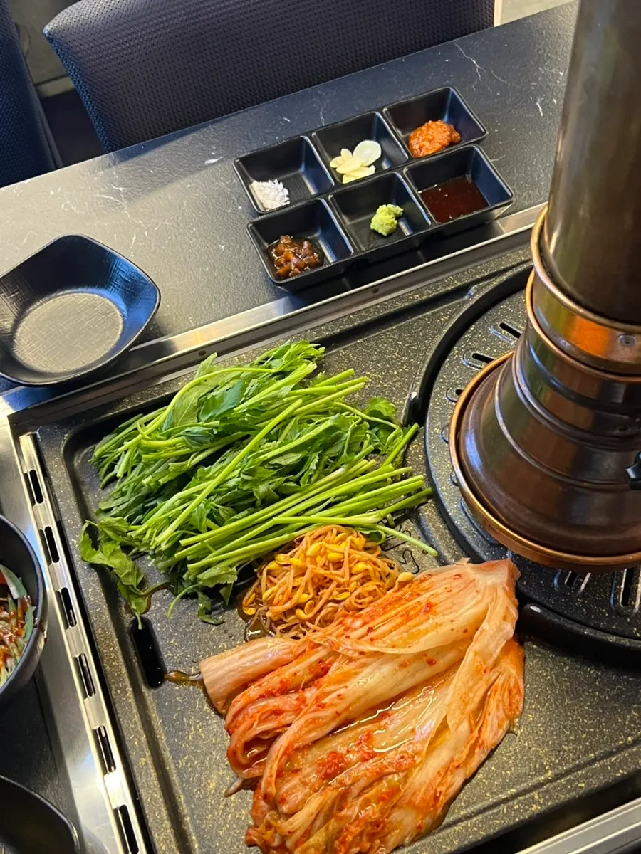 Kimchi and minari cooking under the grill