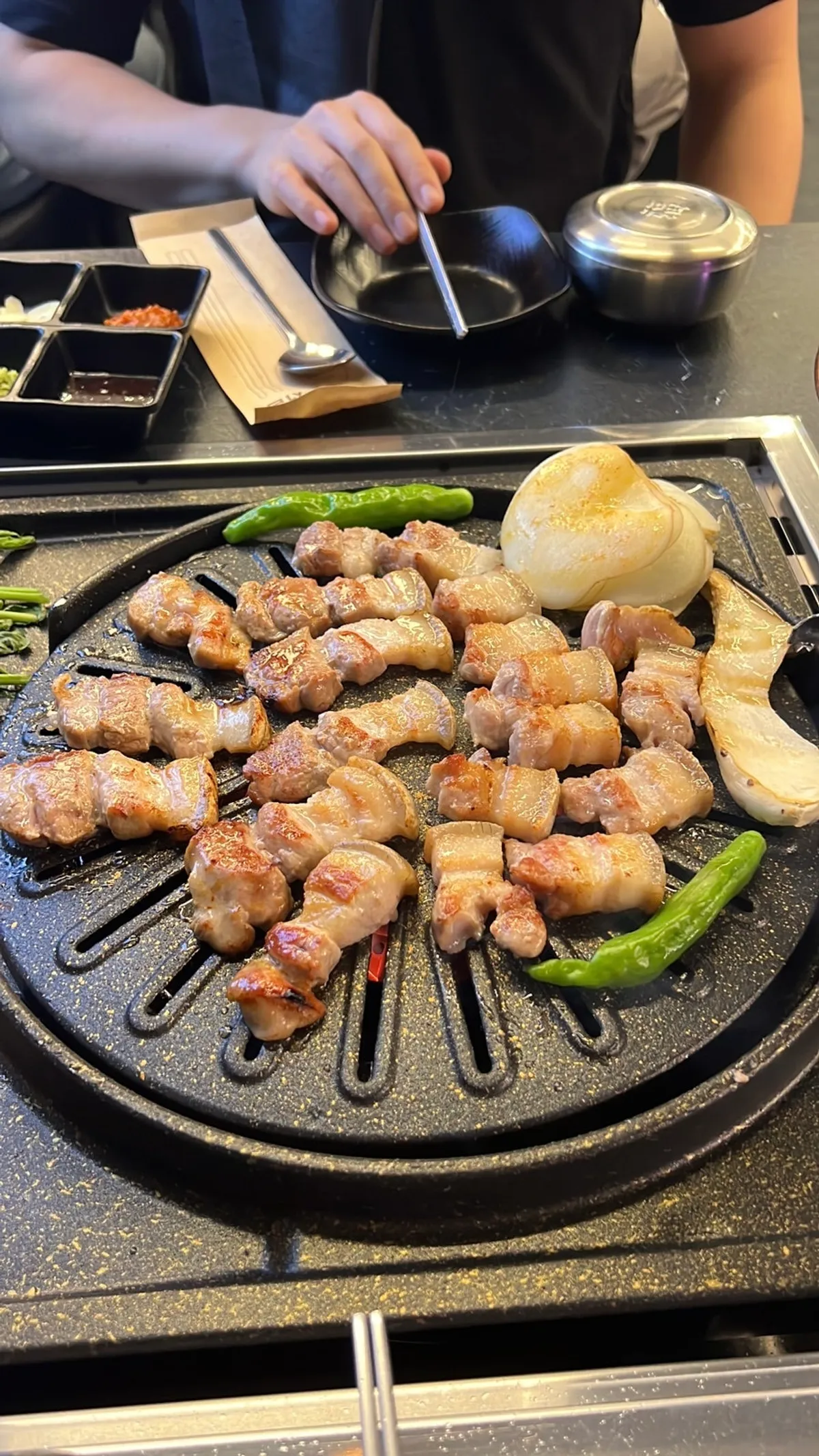 Fully cooked black pork belly slid down to the lower grill