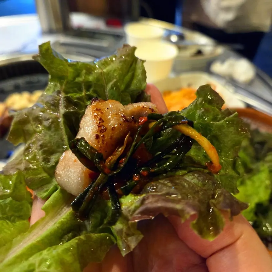 A bite of pork belly wrapped in lettuce