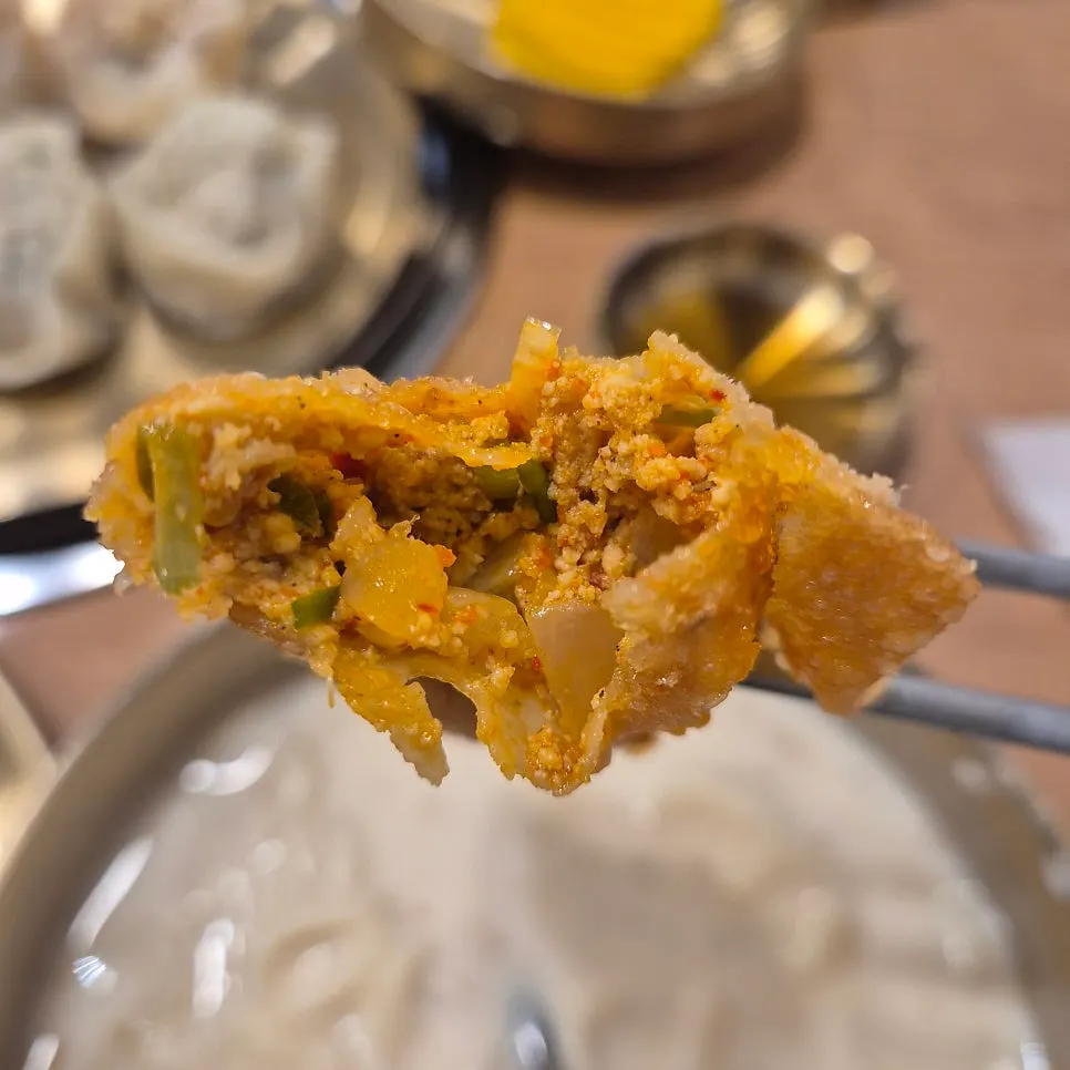 Spicy kimchi filling inside a fried mandu