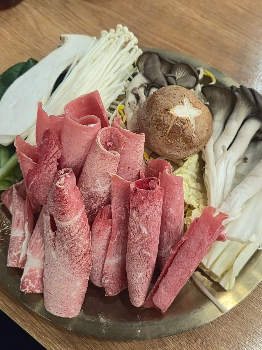 Pot of mandu hot pot filled with meat, vegetables, and dumplings
