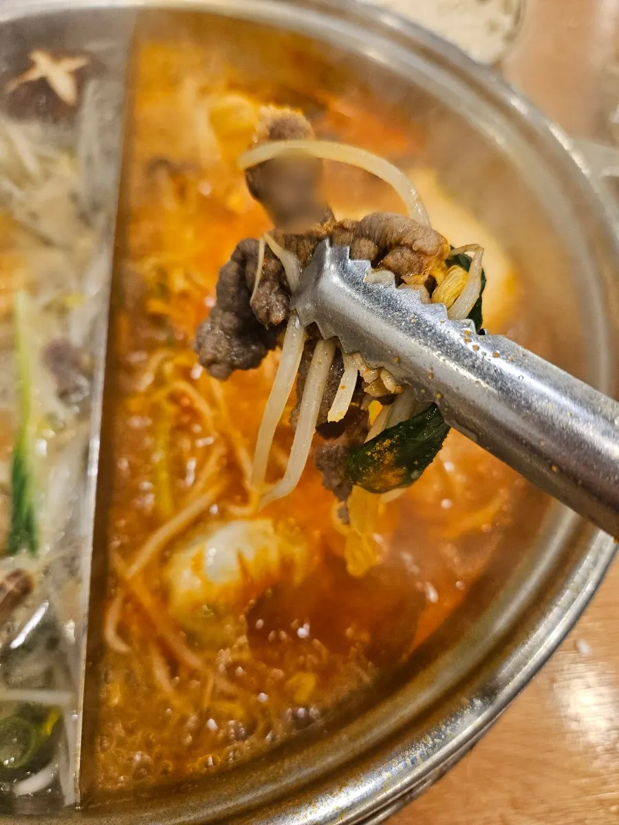 맑은 육수에 담긴 만두와 버섯
