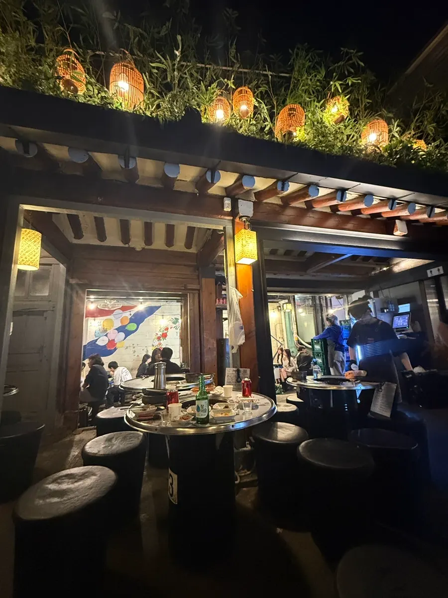 Meongseokjip's indoor seating with an open roof and lighting