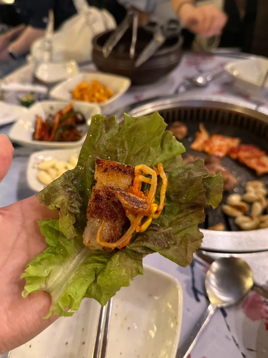 A lettuce wrap with bean sprouts and meat