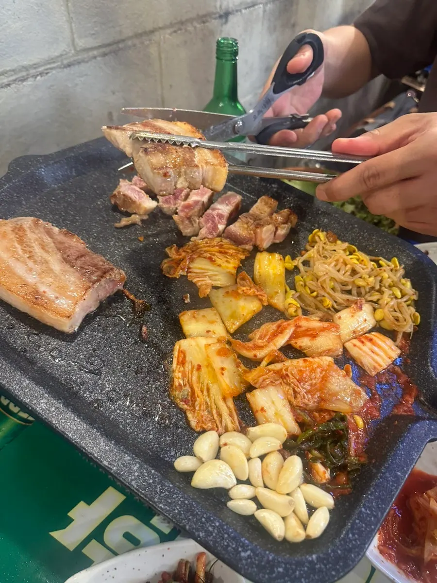 Kimchi and bean sprouts cooking in pork belly fat
