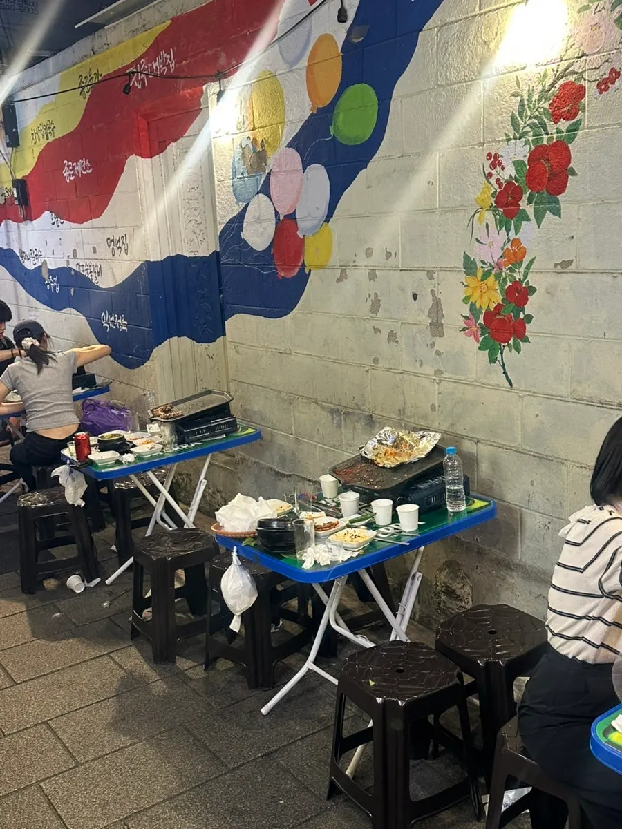 Pork belly, kimchi jjigae, and soju on the outdoor table