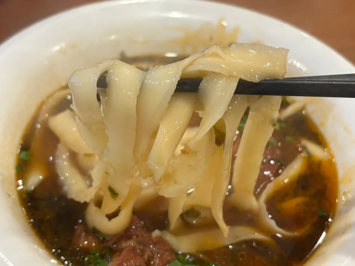 Lifting up the thick, chewy dosakmyeon noodles