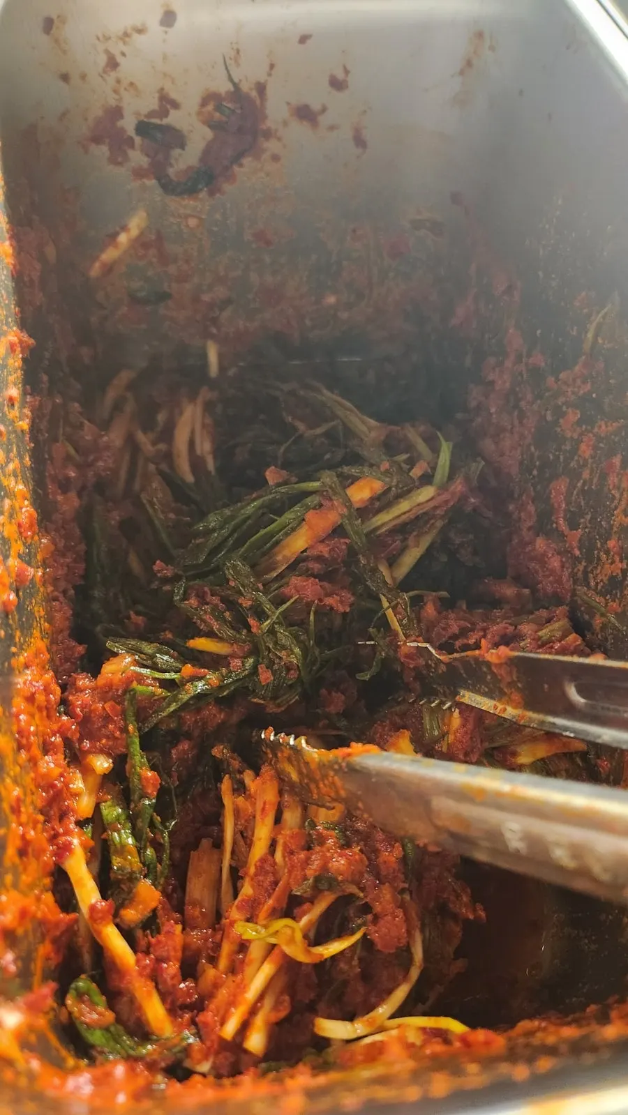 A piece of meat paired with green onion kimchi