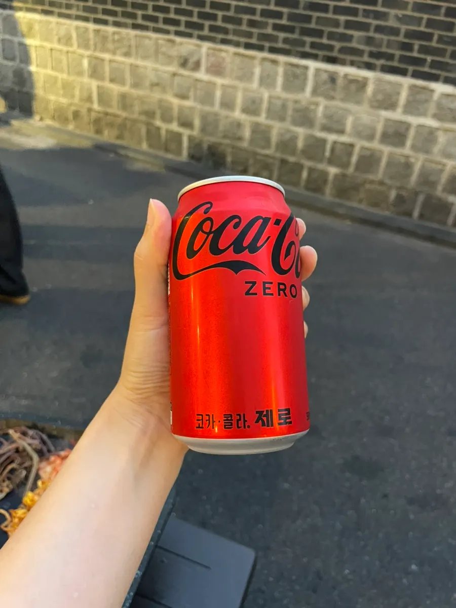 Outdoor seat with a view of the stone wall and a glass of cola