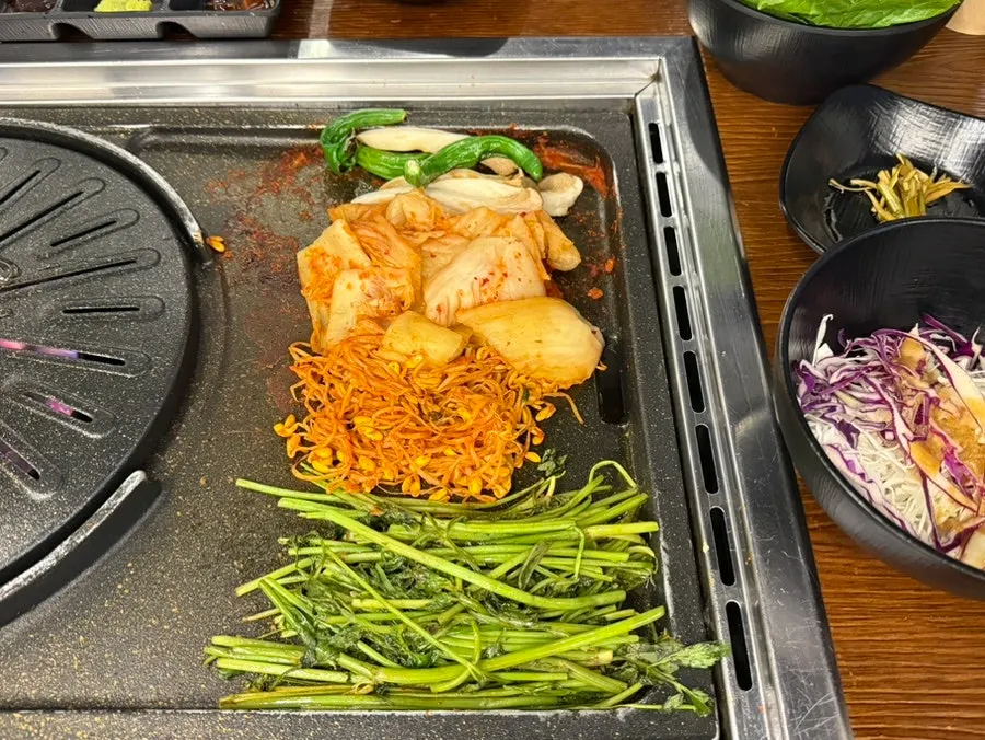 Pork belly stood up with tongs to cook the sides