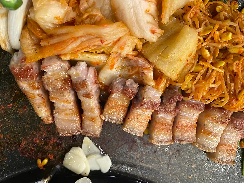 Pork belly sliced into bite-sized pieces with cooked garlic slices