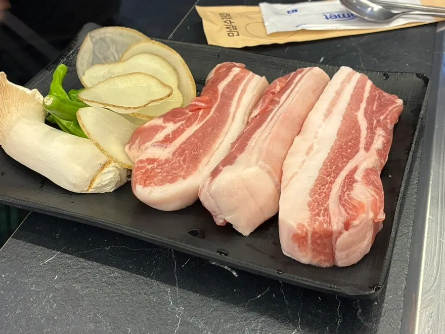 Plate of raw black pork ogeopsal and samgyeopsal ordered