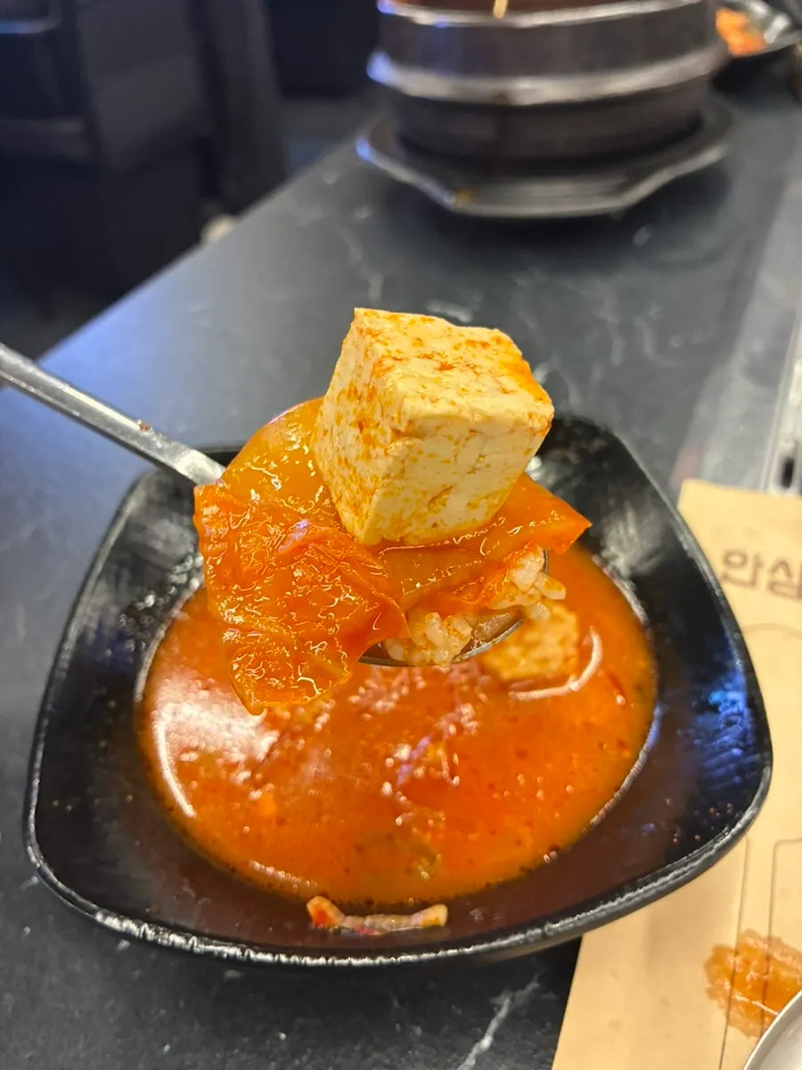 A bowl of rich kimchi jjigae broth