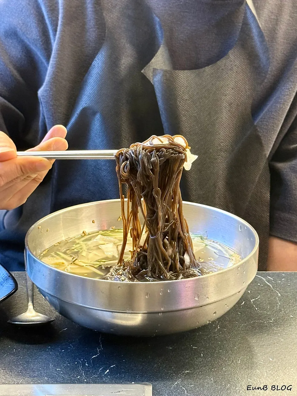 A piece of meat placed on top of the cold noodles