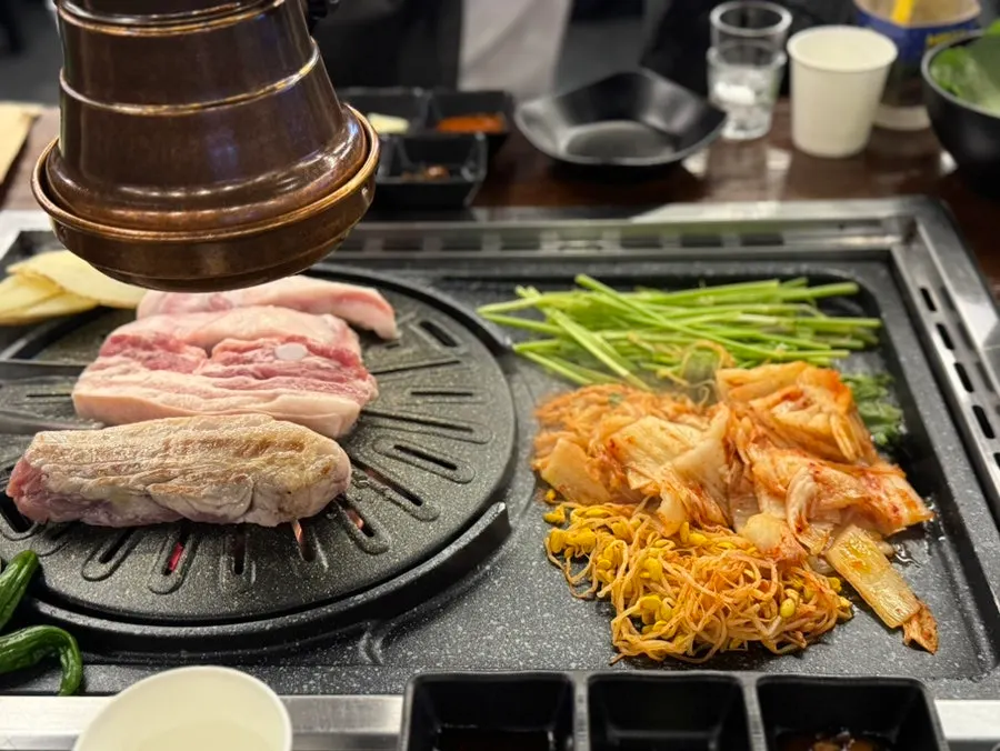 Pork belly on the grill with kimchi on the side
