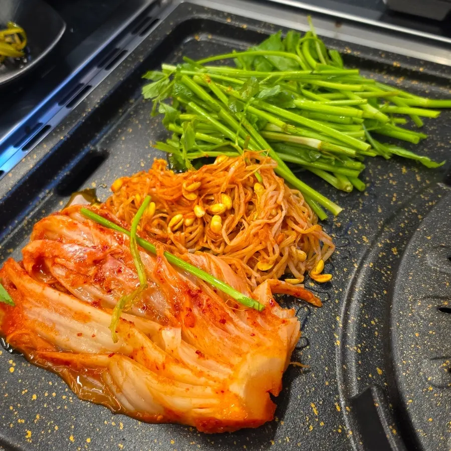 Two servings of cham samgyeopsal with Byeolbitcheongha and mul naengmyeon on the table