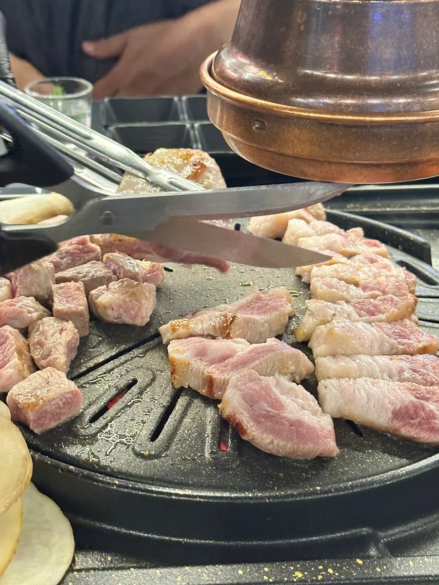 Staff grilling over a charcoal grill