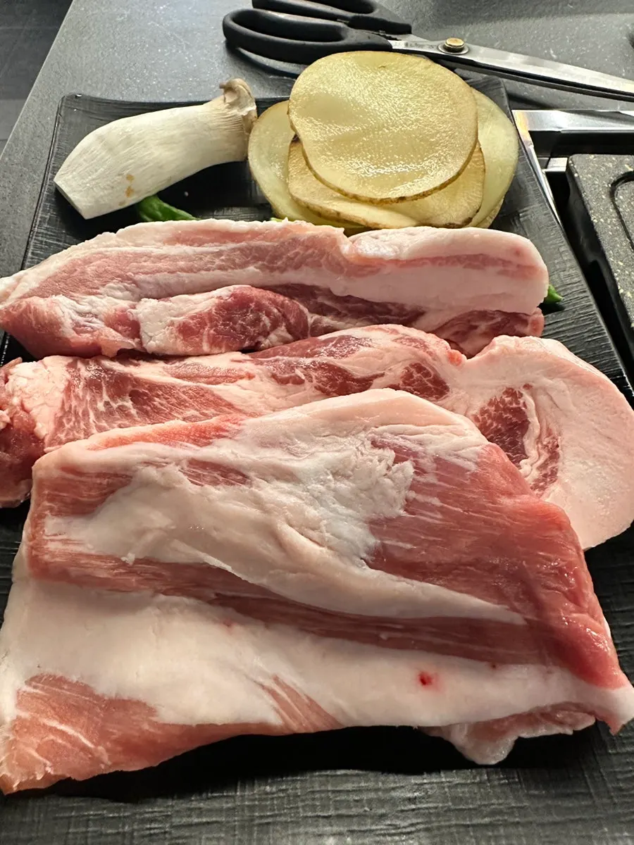 Thick fresh pork belly on the grill