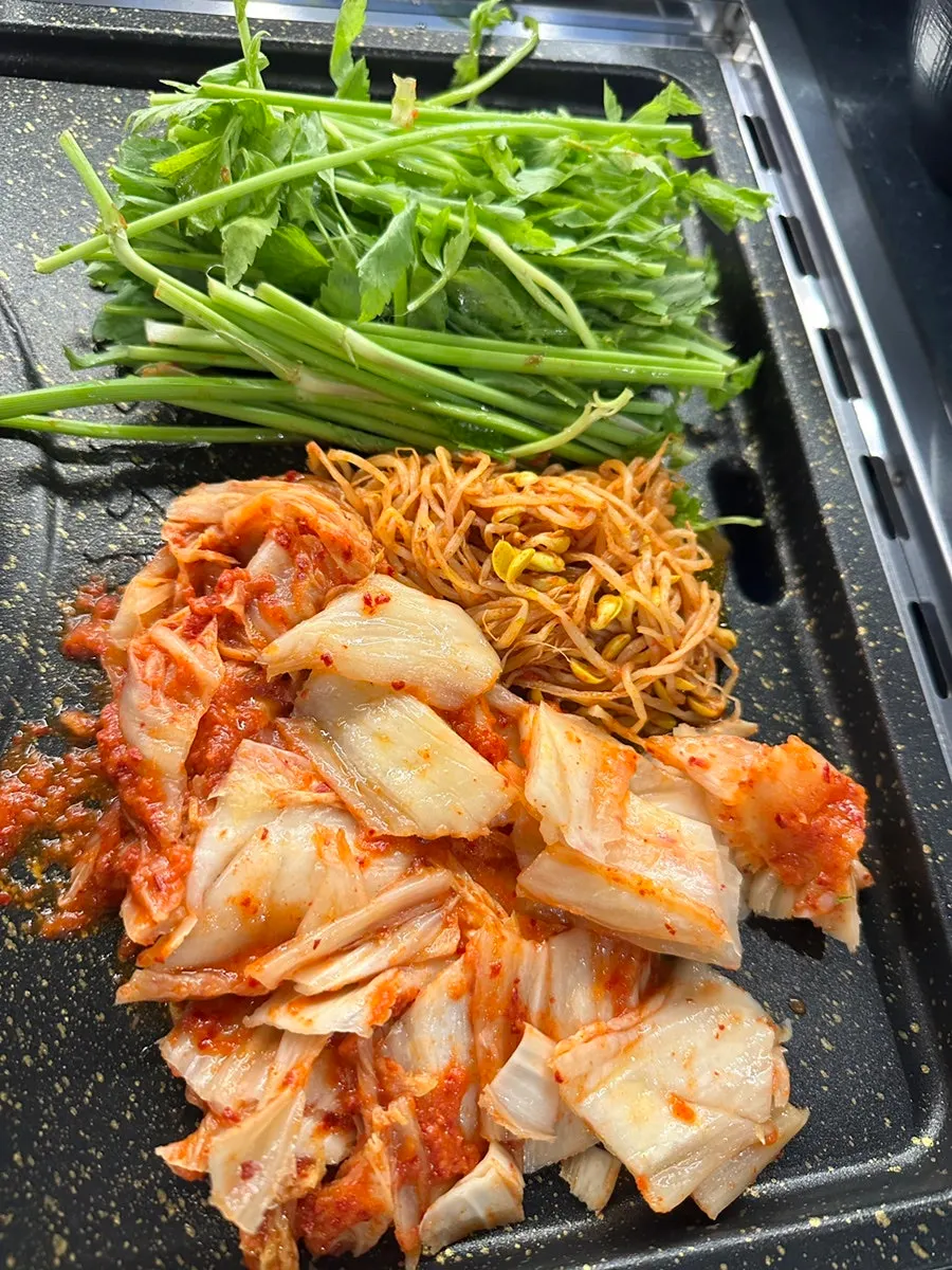 Minari, kimchi, and bean sprouts on the grill