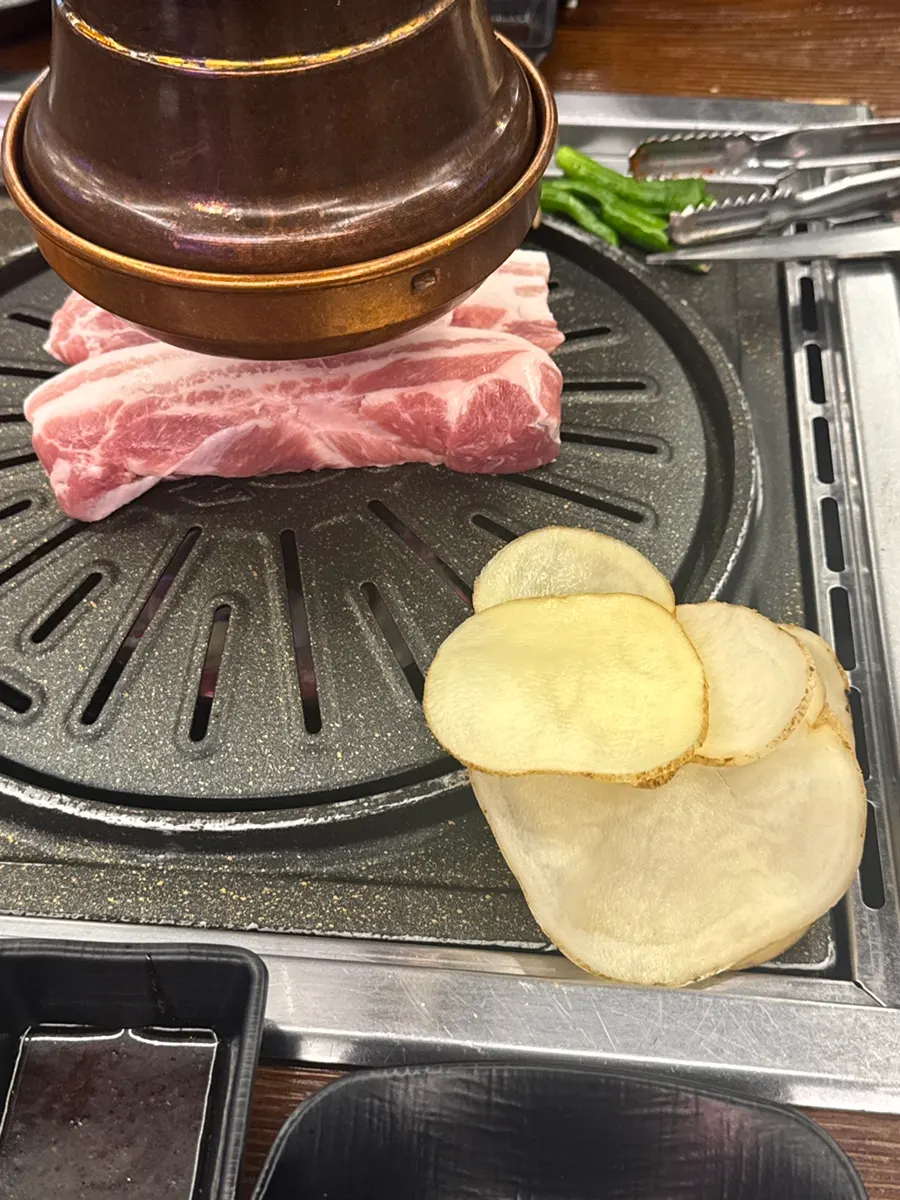 手工烤盤上的五花肉與馬鈴薯薄片