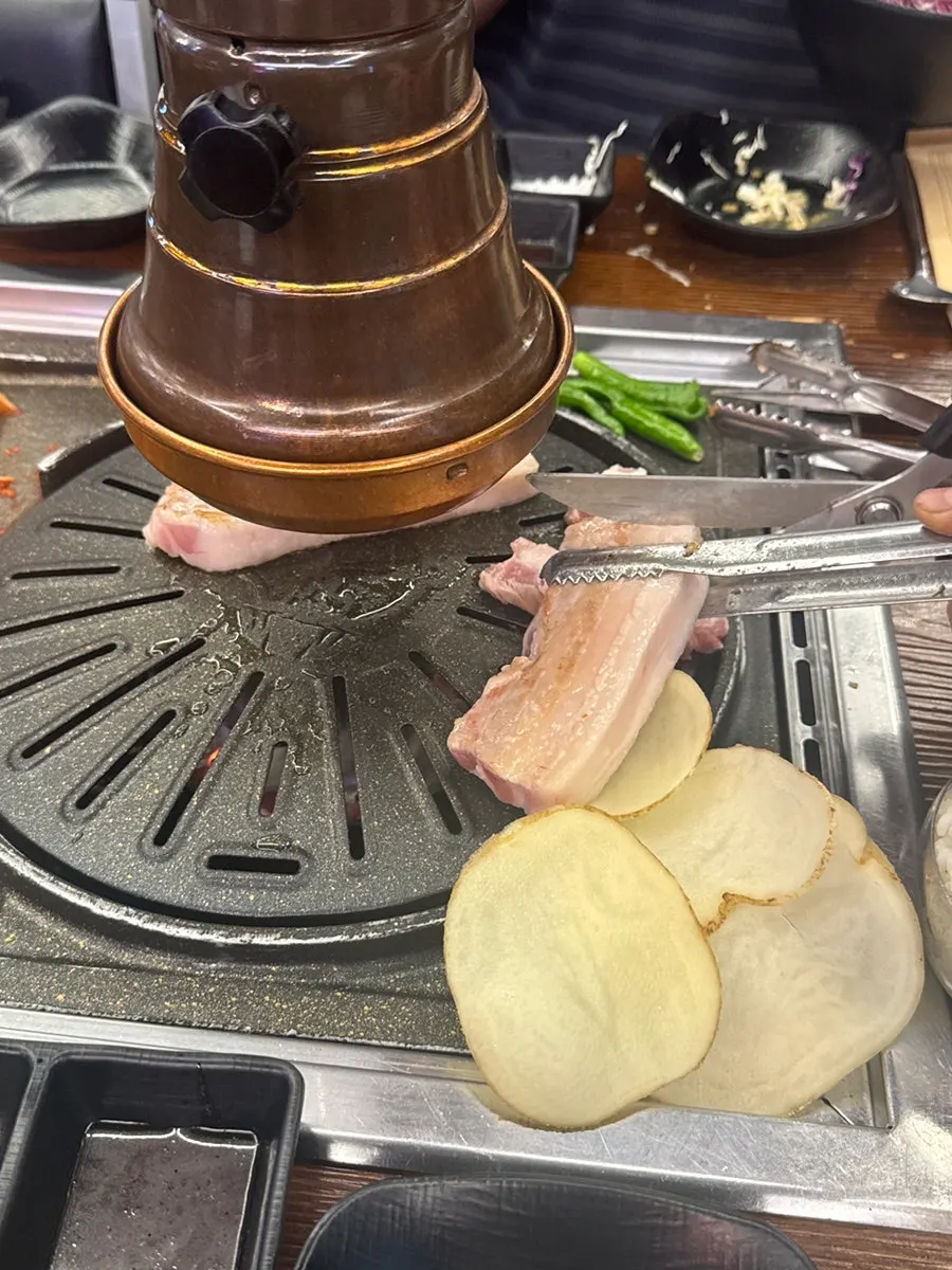 店員代烤炭火五花肉