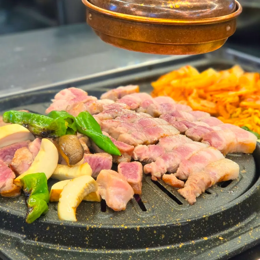 Potatoes, mushrooms, and shishito peppers served alongside the meat