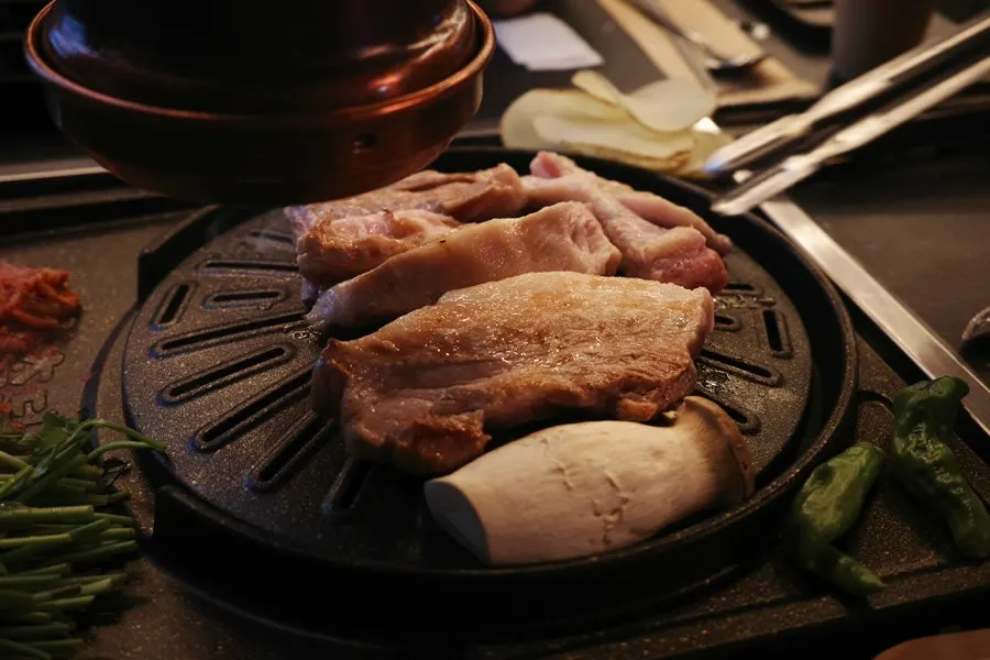 Grill loaded with pork belly and side dishes