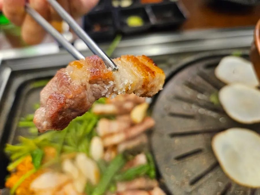 A piece of pork belly dipped in sauce