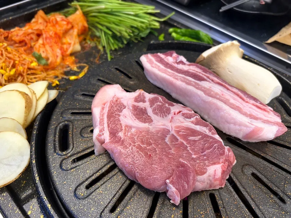 Staff member grilling meat, potatoes and mushrooms on the grill