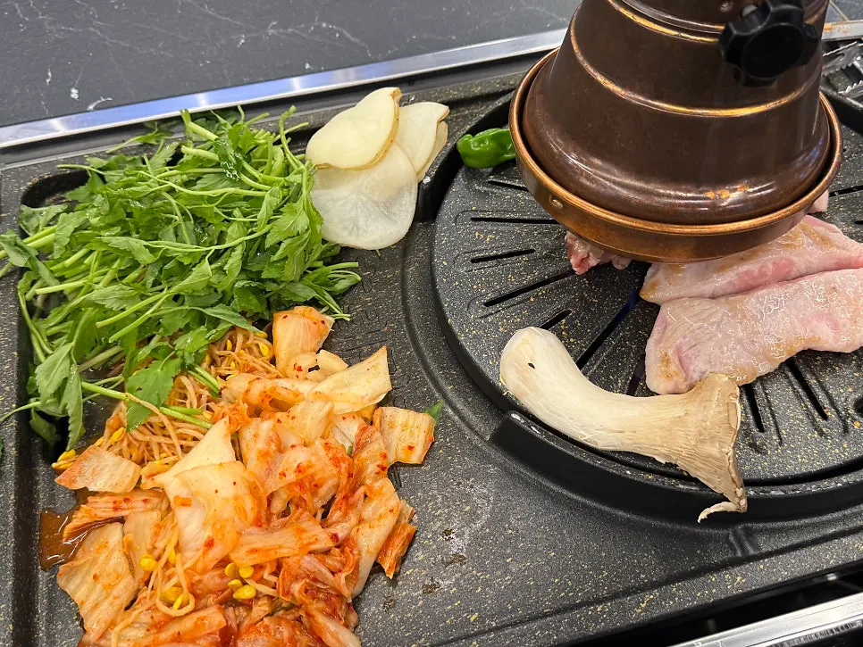 Kimchi, bean sprouts and minari grilled together on the pan