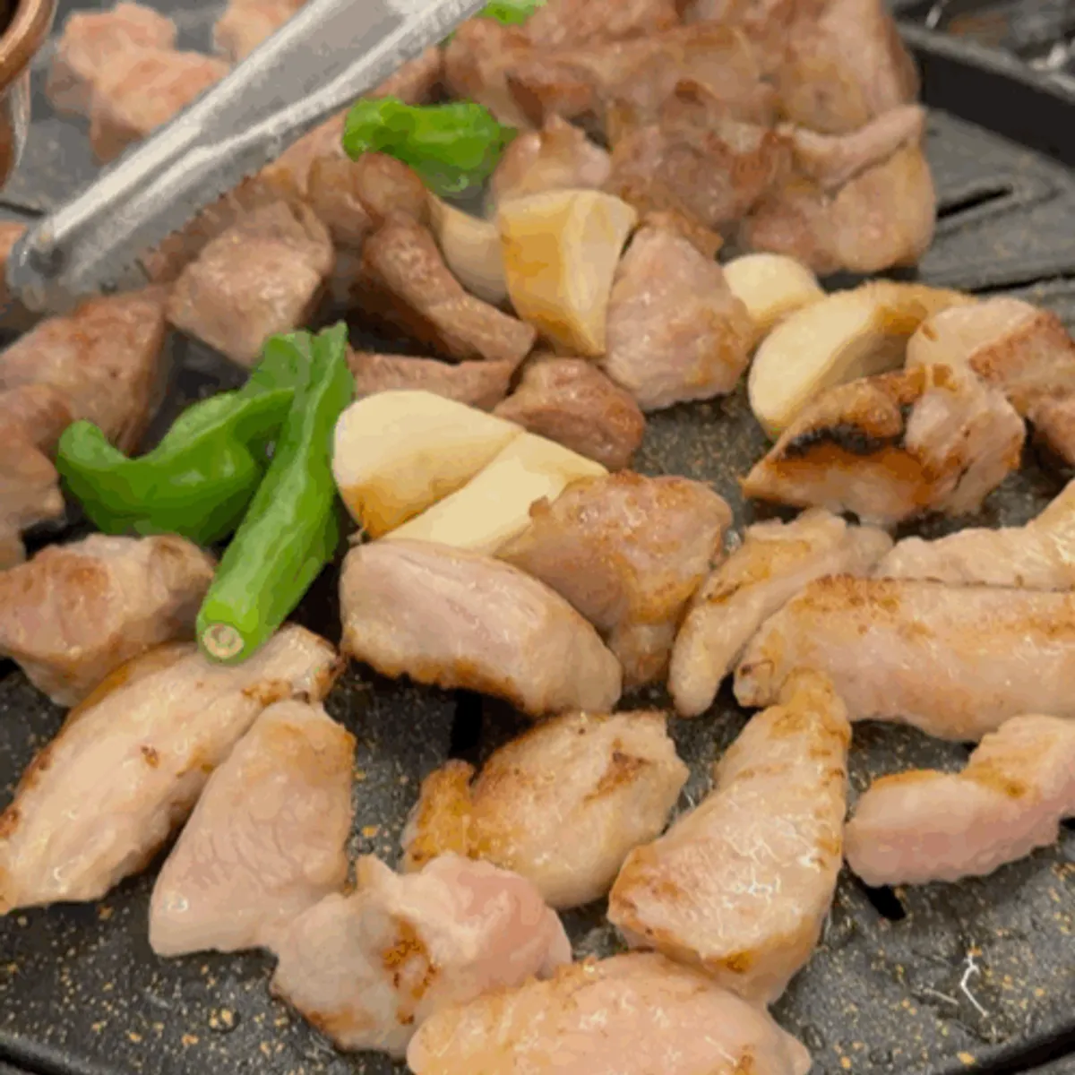 Staff grilling meat on the pan at Cham Dwaejitgan