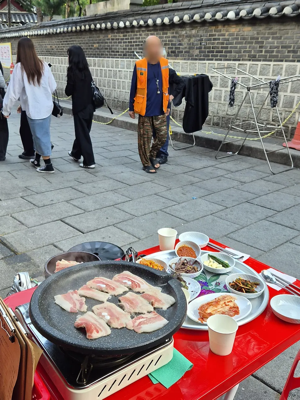 야외 불판에서 구워지는 얇은 냉동 삼겹살